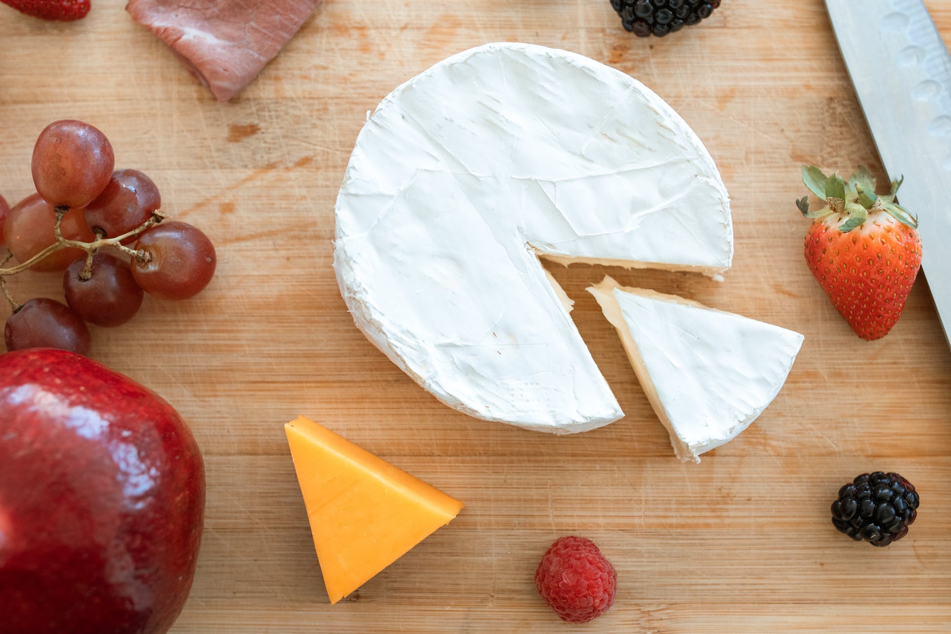 cheese and red apple on brown wooden table