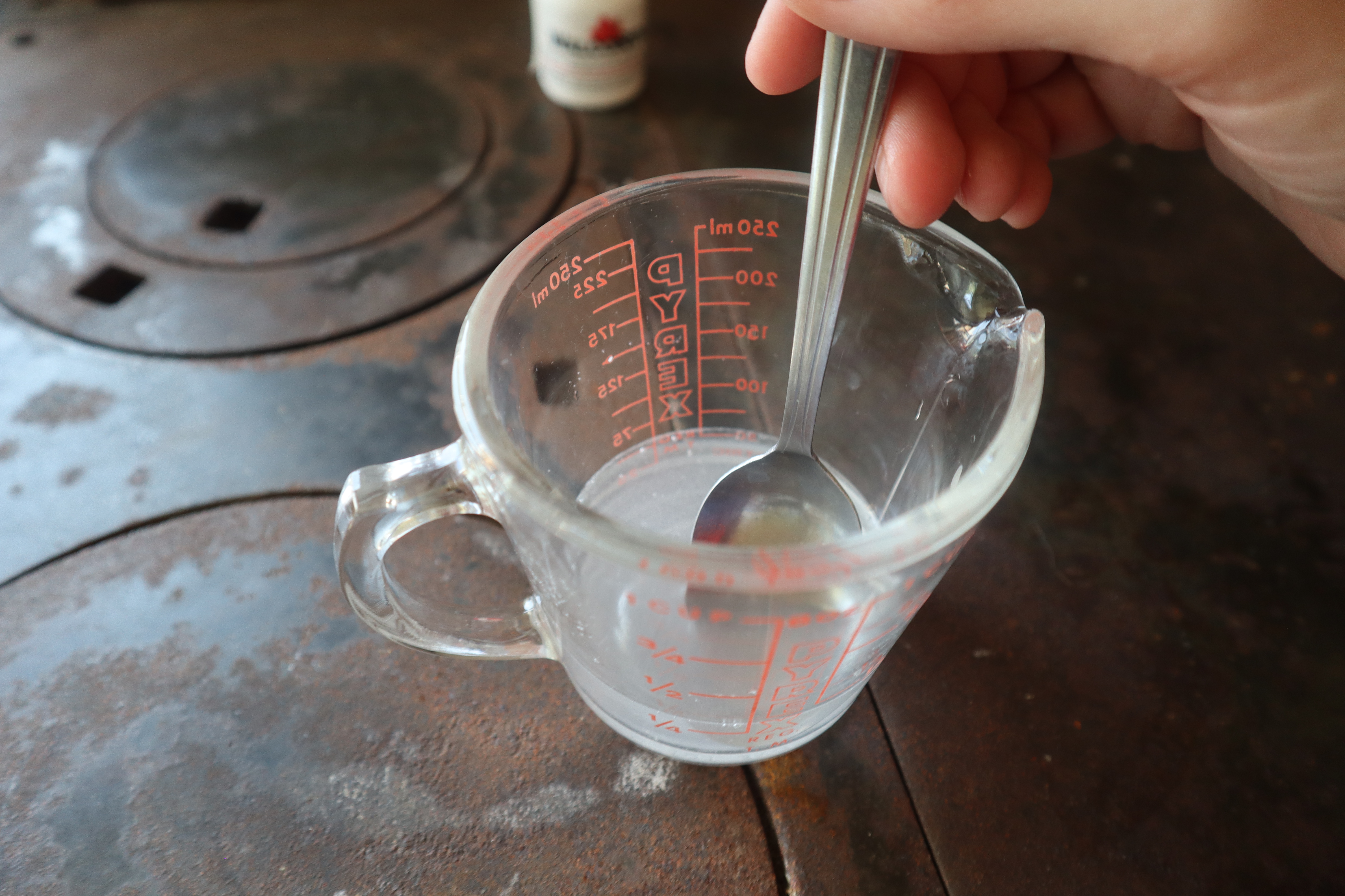 Stirring rennet into a measuring cup 