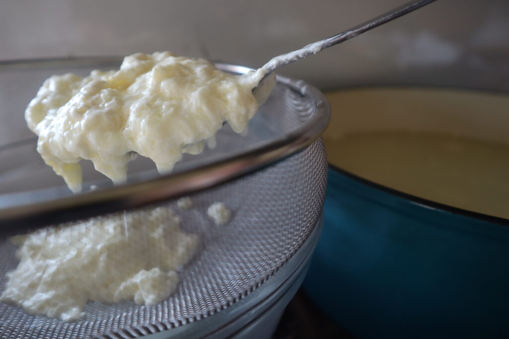 straining cheese through a fine mesh sieve 