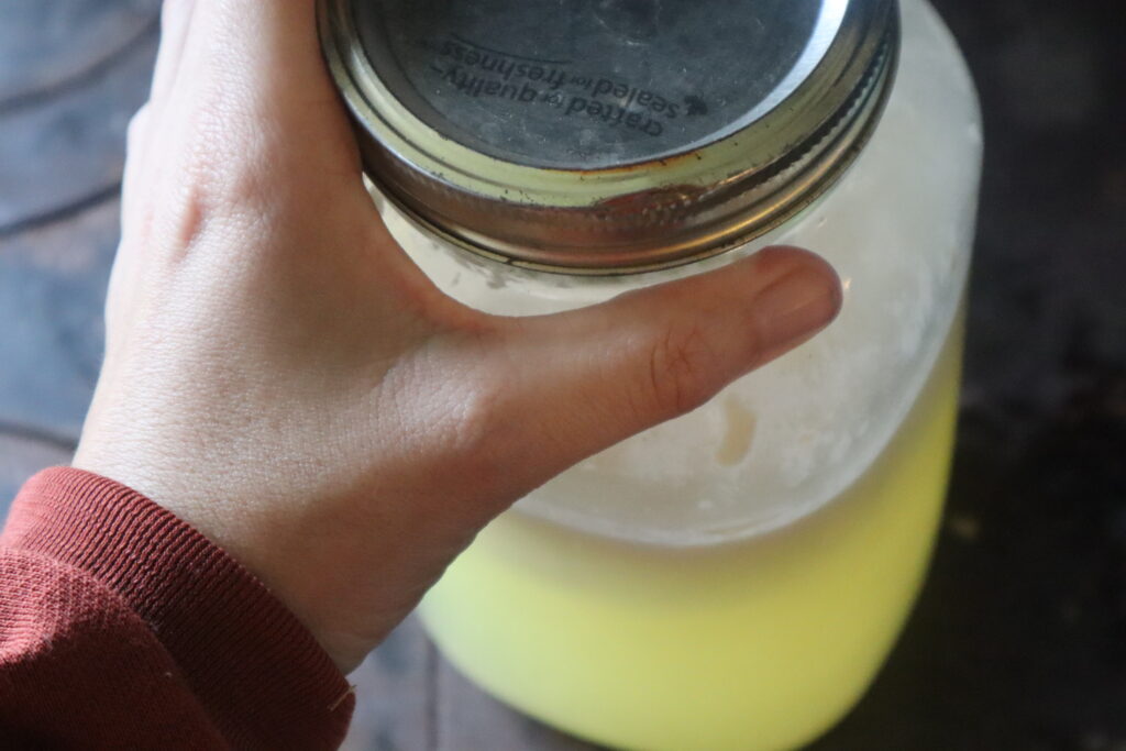 hand on a jar of whey