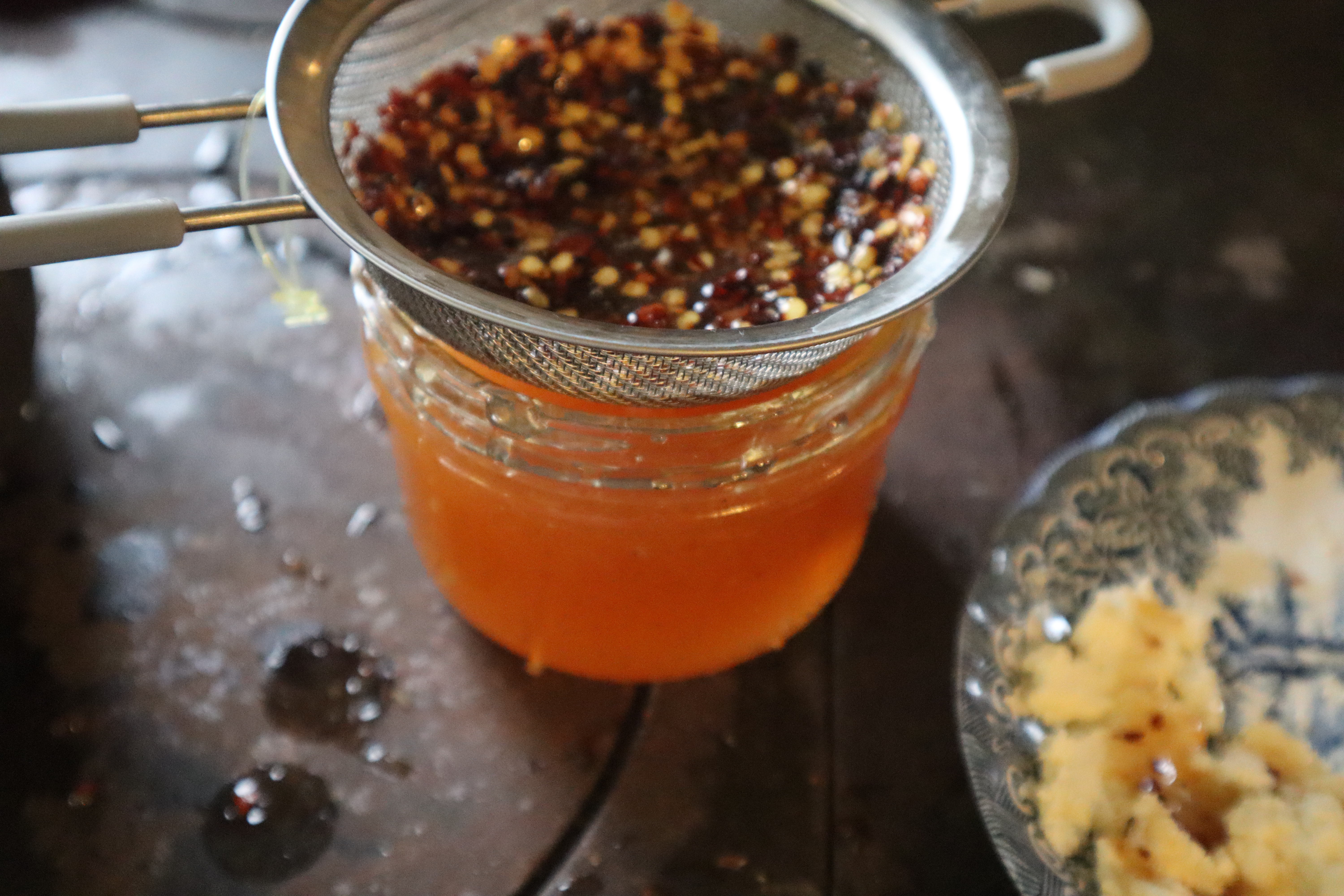 Hot honey straining red pepper flakes 
