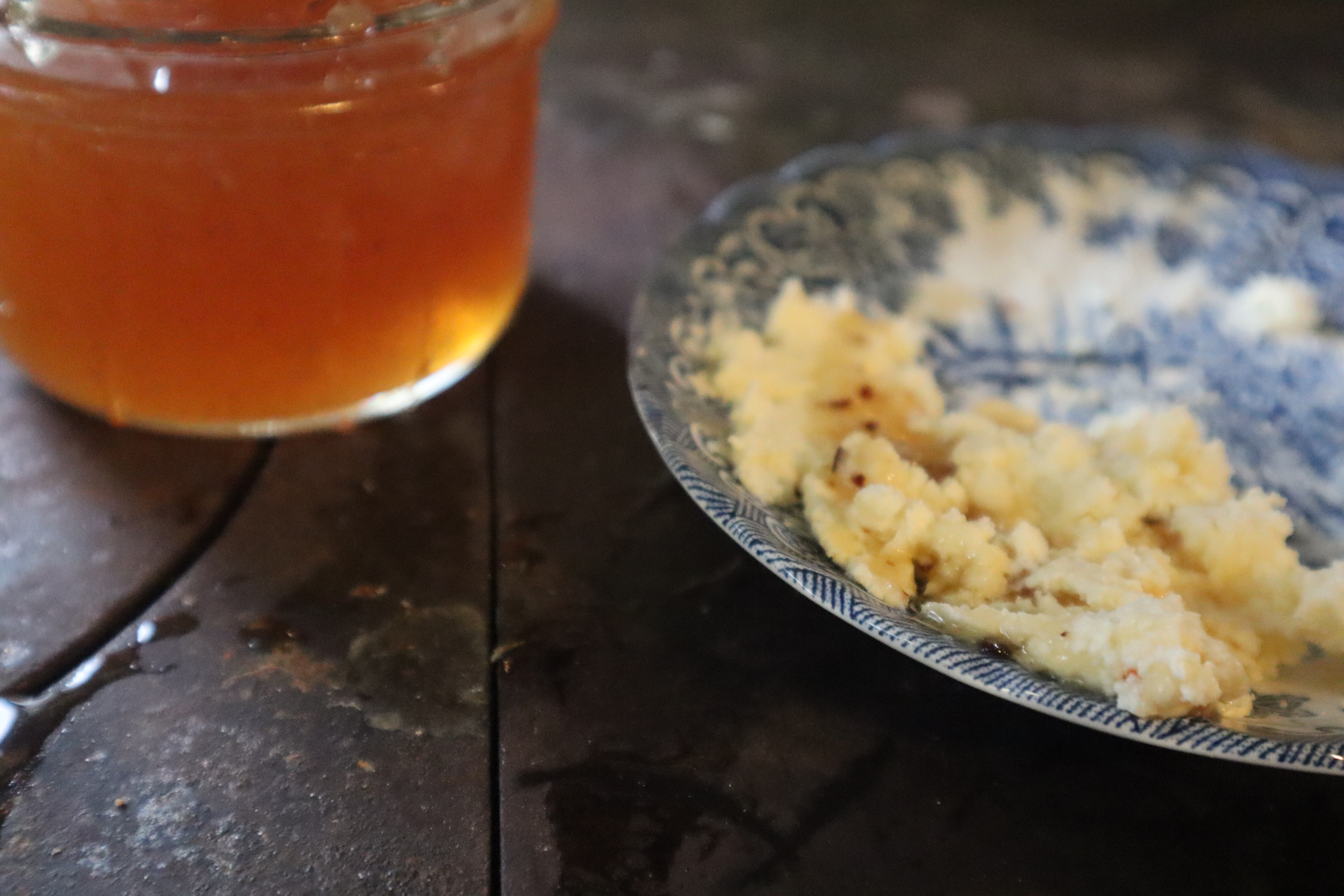 Hot honey beside a plate of homemade quark cheese